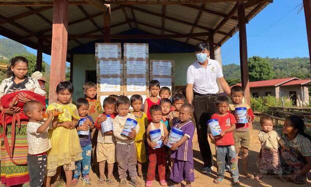 愛緬基金會緬北負責人李添富代表將基督教救助協會捐贈奶粉轉交到臘戌市郊幼童。