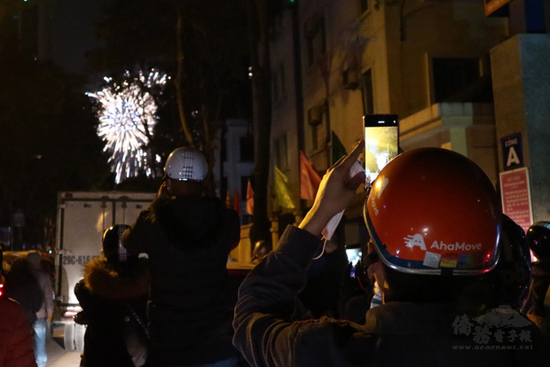 有別遭疫情攻陷的國家黯淡迎接2021年,越南各大景點該辦的跨年活動照辦,首都河內更施放睽違4年的跨年高空煙火。圖為擠不進煙火施放會場的河內民眾坐在機車上享受璀璨一刻。