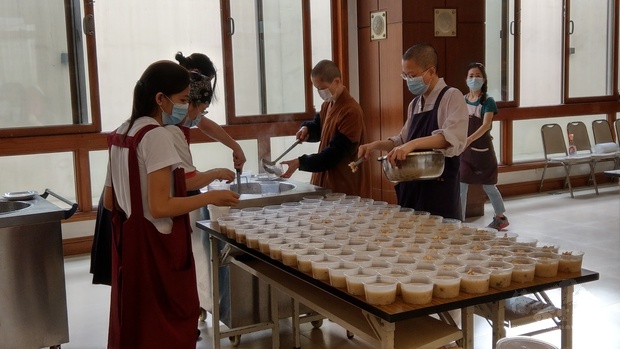 萬年寺法師、佛光山馬尼拉青年團成員及光明大學佛學院學生將臘八粥分裝到耐熱塑料容器。