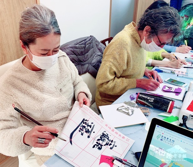 參加者認真臨摹寫吉祥話、折財神爺