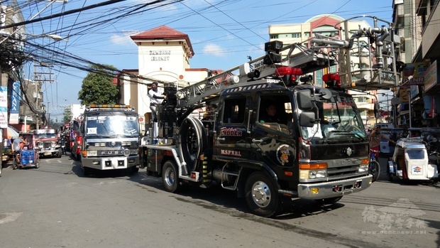 菲華義勇消防隊的救災車輛開警示燈及鳴笛經過僑校密集的馬桑凱街。