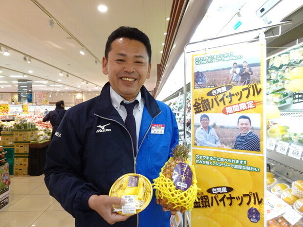 日本連鎖超市BELX的青果商品部課長小川能弘特別在台灣鳳梨專區掛著他去年2月在屏東與果農的合照做宣傳。他說今年進口台灣鳳梨數量將是去年3倍。(中央社提供)