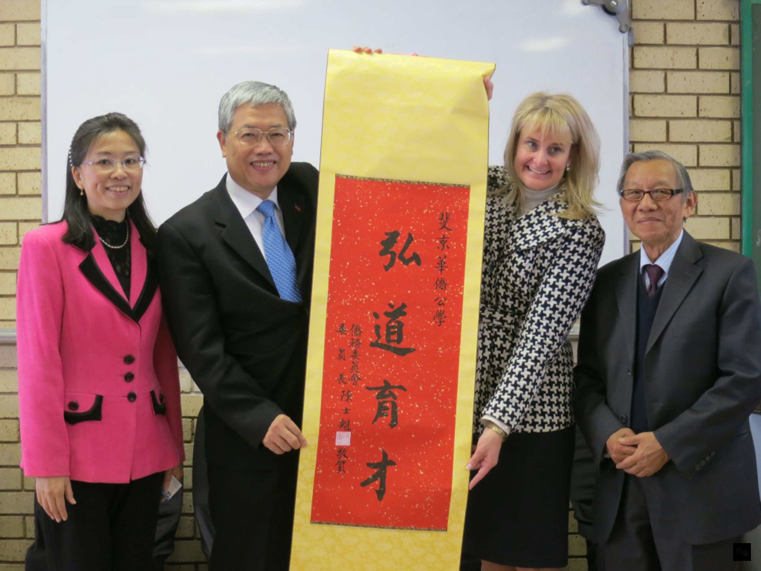 僑委會委員長陳士魁(左二)拜訪南非斐京華僑公學,致贈學校禮物,由校長倪麗澤(Lisette Noonan)(右二)代表接受。(中央社提供)