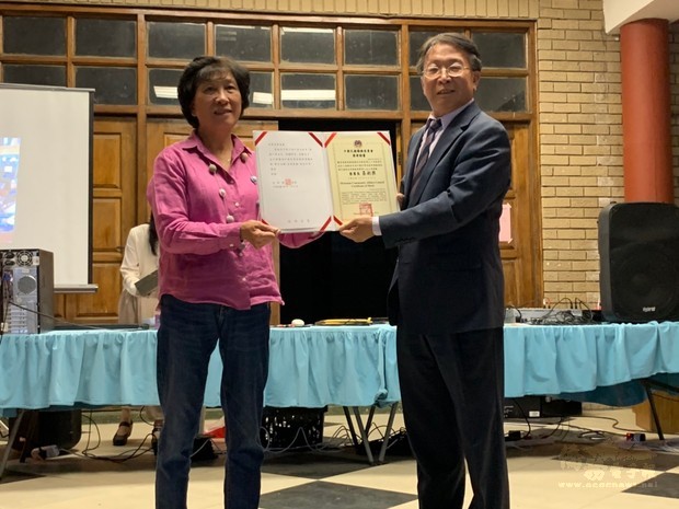 賴金城代表僑委會頒發30年教師獎勵給優良教師蕭素華。