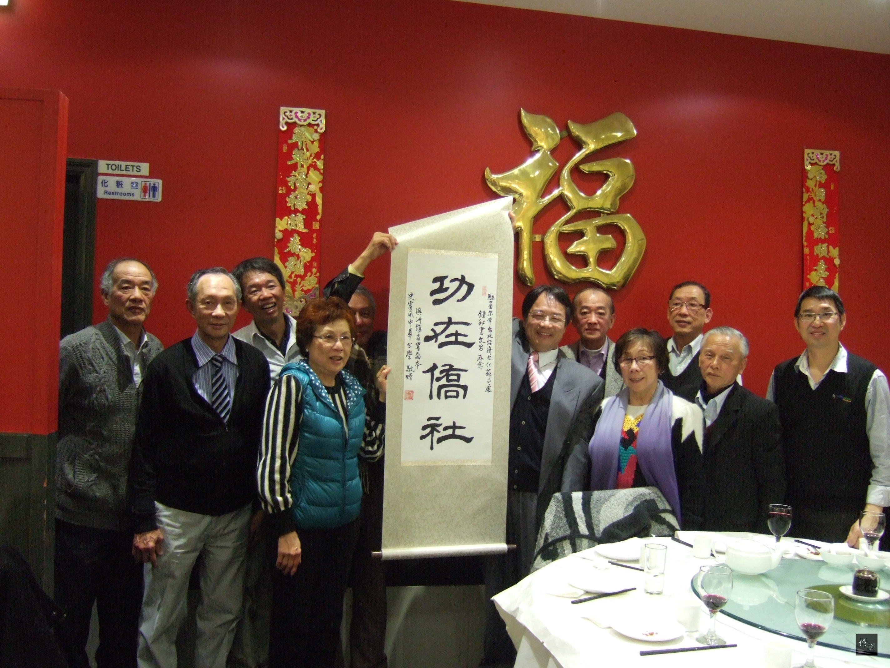 駐墨爾本辦事處僑務秘書鍾文昌即將榮調回國，當地僑社設宴歡送，中華公學理事會贈送「功在僑社」掛軸。（世界華文作家交流協會秘書長黃玉液提供）