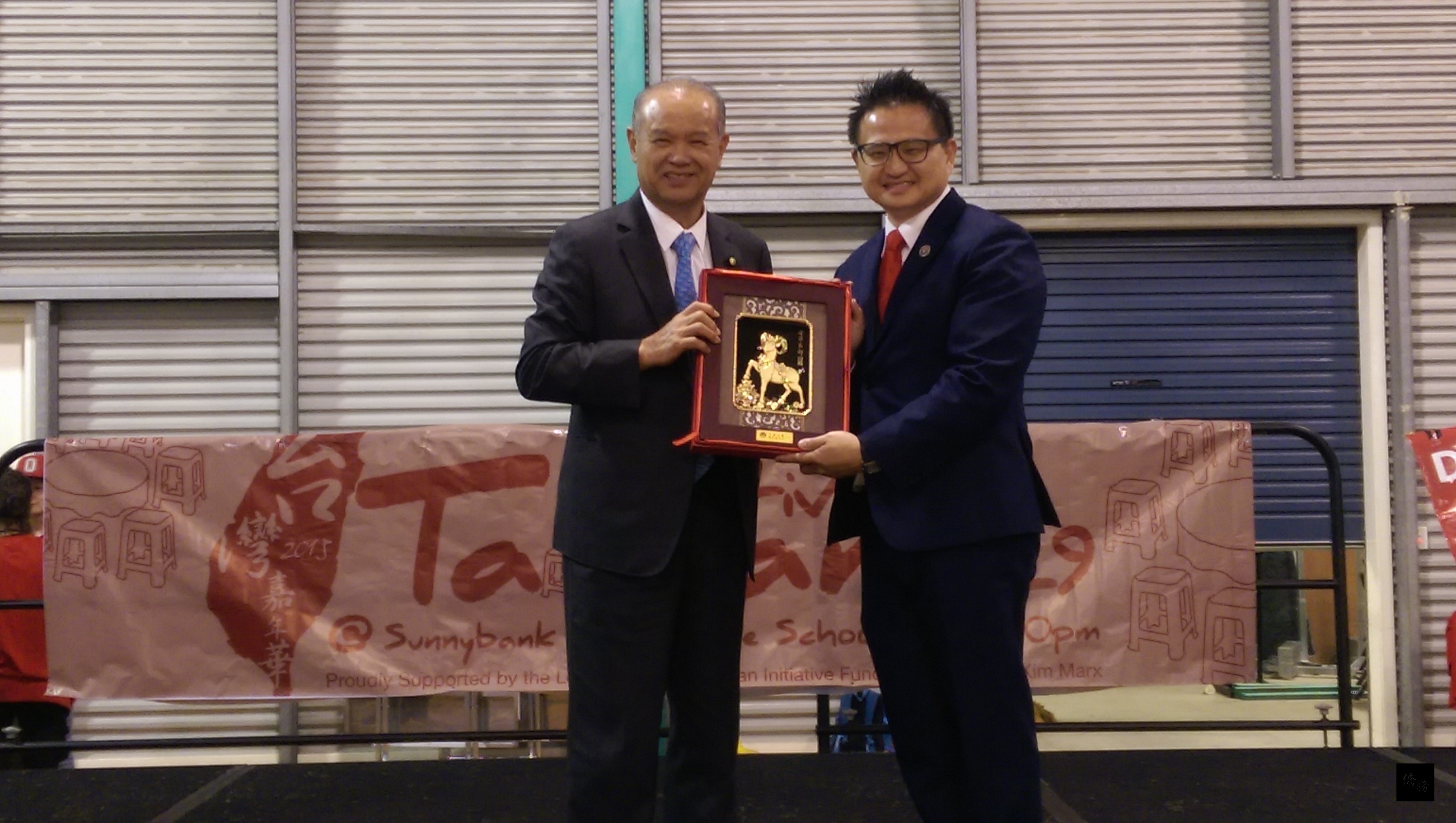 國慶文化訪問團團長，總統府國策顧問黃正勝贈獎牌予澳洲昆士蘭台商會會長許柏亭。（布里斯本僑教中心提供）