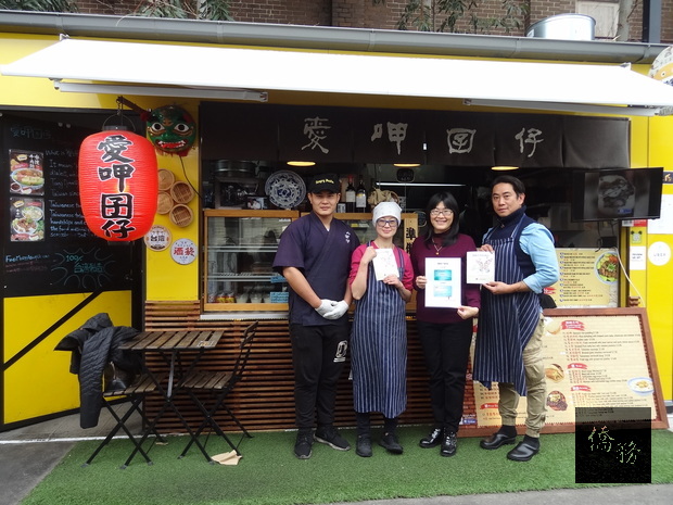 主任吳春芳(右二)親送僑胞卡特約商店識別貼紙予HungryPaulie愛呷囝仔負責人朱冠龍(右一)