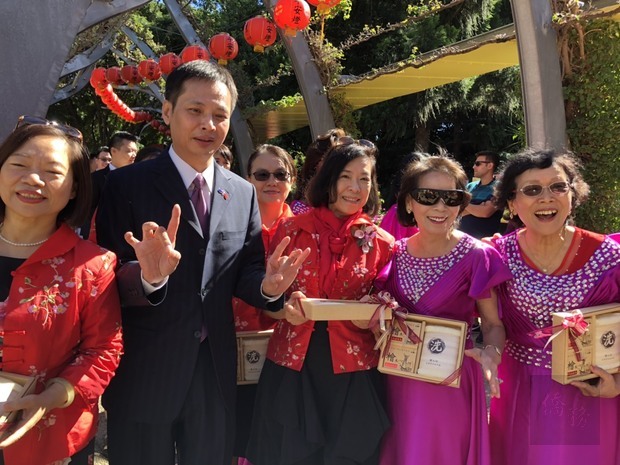 洪振榮與進獻貢品僑團合影