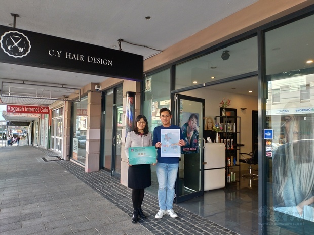 吳春芳(左)頒贈僑胞卡特約商店標章予業者(右)。