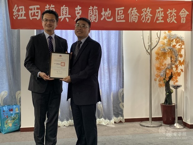 劉永健(左)頒發太平紳士賀狀予易立仁(右)。