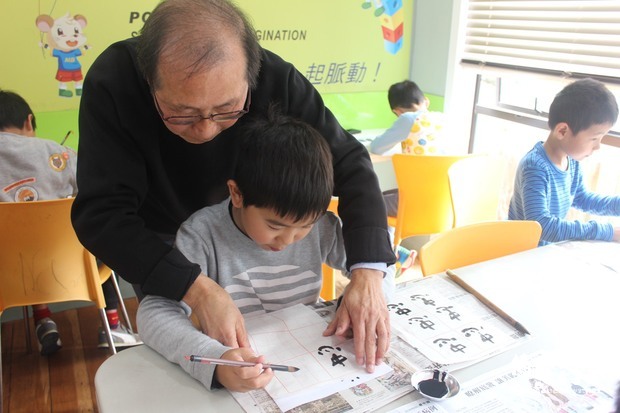 黃振鍹老師指導學生習寫書法。