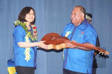 President Tsai Ing-wen, left, presents an acoustic guitar, handmade by a Taiwanese Aboriginal luthier, as a gift to Nauruan President Baron Divavesi Waqa in Nauru yesterday./Photo courtesy of Taipei Times