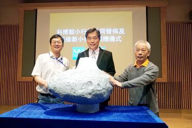 National Museum of Natural Science Director-General Sun Wei-hsin, center, Lulin Observatory director Lin Hung-chin, left, and observatory assistant Lin Chi-sheng pose with a model of an asteroid at a ceremony at the museum in Taichung yesterday./Phot