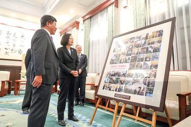 President Tsai Ing-wen, second left, and Minister of Health and Welfare Chen Shih-chung, left, look at photographs at the Ministry of Health and Welfare yesterday that show the Taiwanese delegation’s visit to the ongoing World Health Assembly in Gene