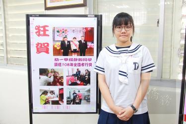 Yang Ching-ju stands next to a notice announcing her receipt of a National Piety Award at Da Der Commercial and Technical Vocational School in Changhua County’s Tianjhong Township on Monday./Photo courtesy of Taipei Times