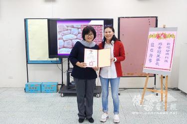 Businesswoman Yu Su-kuan, right, holds an award presented by Chungher Elementary School principal Liu Wen-chi in Keelung on Saturday./Photo courtesy of Taipei Times