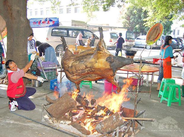 A man roasts a pig in Nantou County in an undated photograph./Photo courtesy of Taipei Times