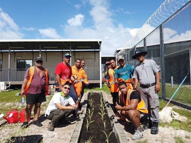 A member of the Taiwanese technical mission in Nauru poses for photo with participants of the penal farm project. / Photo courtesy of ICDF.