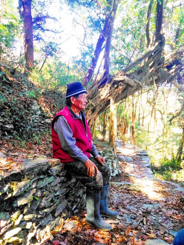 Eighty-year-old Ripunu Abalriini on Monday last week sits by a trail that he helped to build in Pingtung County’s Wutai Township. / Photo courtesy of Community Forestry Laboratory of National Pingtung University of Science & Technology
