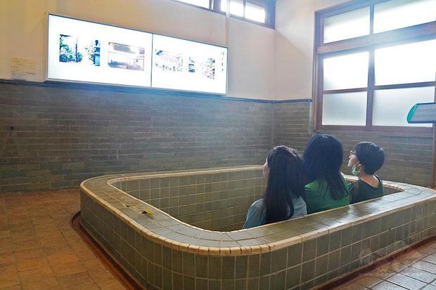 Visitors on Saturday sit in an empty bath in a public bathroom at the the Beitou Museum to watch a briefing about the museum, which used to be a hot spring resort during Japanese colonial period.／Photo courtesy of CNA