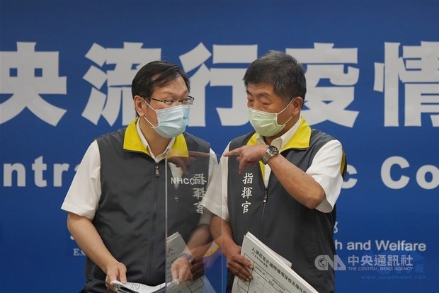 Health Minister Chen Shih-chung and CECC spokesman Chuang Jen-hsiang chat before the press briefing.／Photo courtesy of CNA
