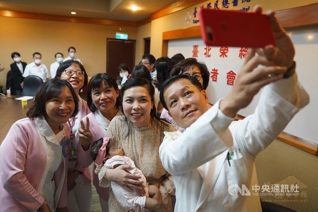 Le Van Dai Trang, carrying her baby daughter, poses for a group selfie with the medical staff at Taipei Veterans General Hospital on Monday /Photo courtesy of CNA