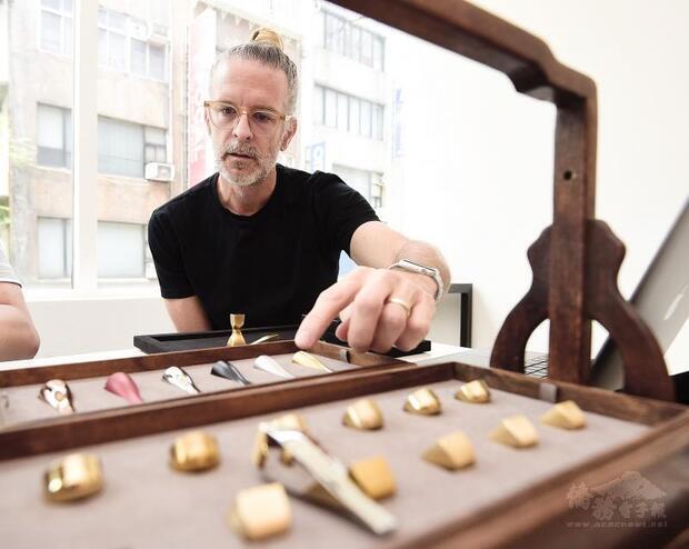 Brand consultant Mark Stocker displays his innovative name stamps during a news conference in Taipei on Aug. 24./Photo courtesy of Taipei Times
