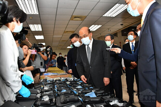 Premier Su Tseng-chang (center) applauds the Criminal Investigation Bureau for the largest seizure of illegal ammunition in Taiwan's history.