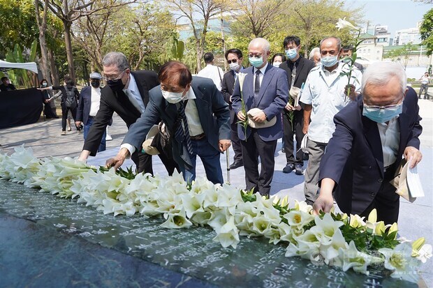 People lay white lilies at the memorial in Kaohsiung. CNA photo Feb. 28, 2021