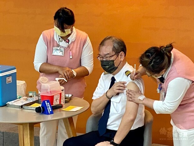 China Airlines President Kao Shing-hwang (center), a trained pilot, receives a COVID-19 vaccine shot. 