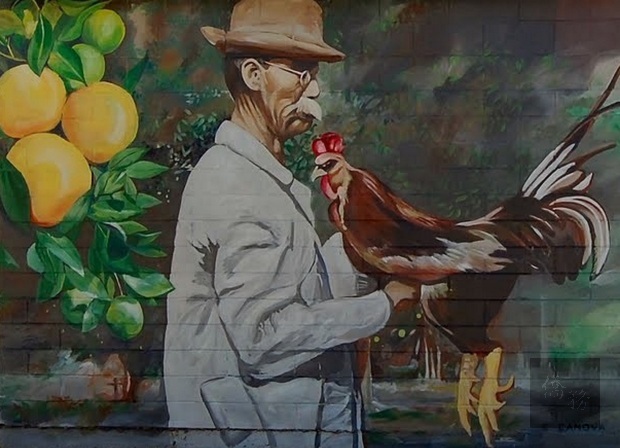 迪蘭市市中心一座建築物整個牆面呈現出呂金功和公雞同框壁的壁畫。