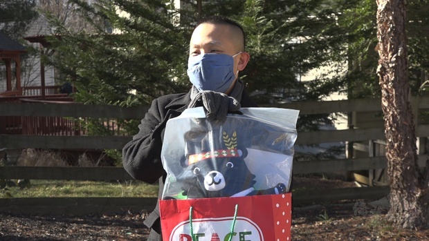 林力圖接受華府僑教中心致贈的臺灣黑熊式樣的頸枕。