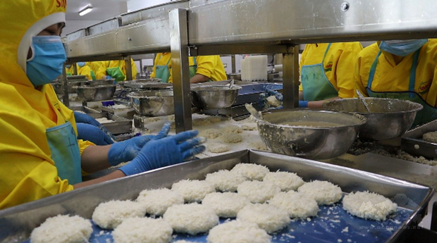 陳信銘2008年起在越南養蝦，並陸續為海底撈、摩斯漢堡供貨。他的蝦池一平方公尺平均可以養出300尾、每尾重量20克的白蝦。圖為正在製作蝦堡內餡的工人。