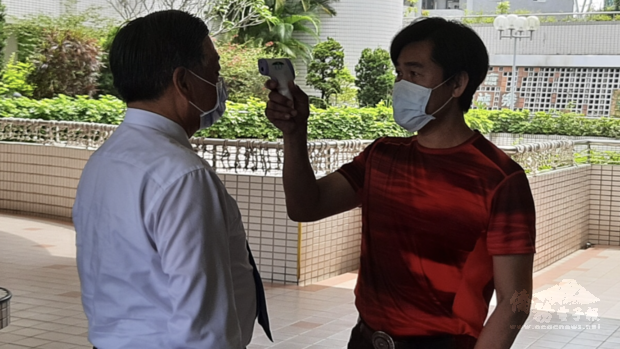 僑委會副委員長呂元榮(左)進入中山工商時接受額溫槍檢驗體溫。