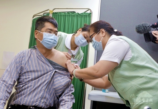 武漢肺炎AZ疫苗自費接種21日開打，前往新北市亞東醫院接種的民眾洪先生（左）表示，比起罹病，雖有副作用之虞，相對更有保障。