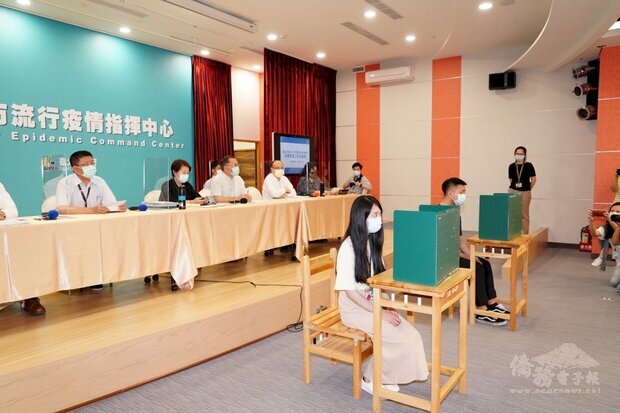 台北市政府12日舉行記者會說明國中會考的防疫措施，並示範考生使用多功能隔板用餐。(北市府提供)