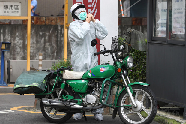 國內疫情延燒，新北市板橋區亞東醫院爆發院內傳染案件，一名郵局的郵務士17日到亞東醫院送件時換上防護衣，加強防疫。