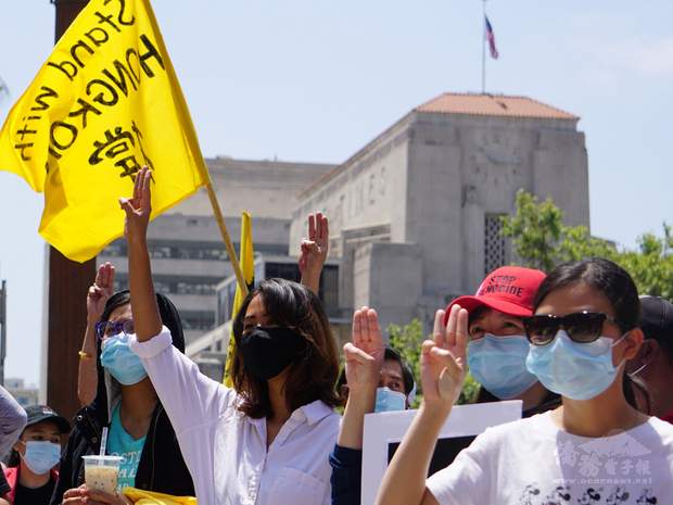 來自台灣、泰國、香港、緬甸追求民主的人士8日集結在洛杉磯市政府前，發聲反對暴政，群眾高舉象徵人民的三指手勢。背景為洛杉磯時報大樓。