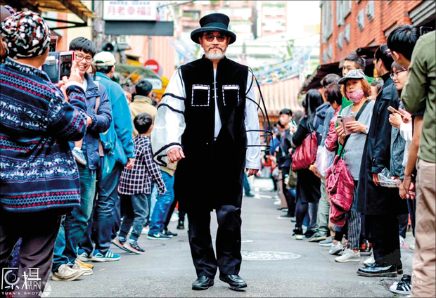 退休醫師林經甫，去年底穿著一套黑白色以皮影戲為概念發想的服裝在大稻埕街頭走秀，因為這張照片紅到國外。（林經甫提供）