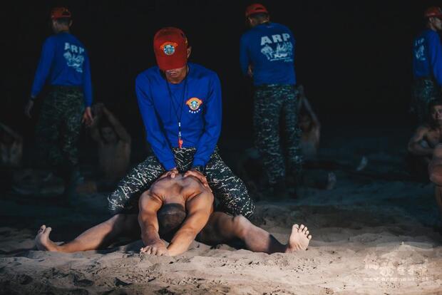 測驗前教官輔助學員拉筋熱身，避免運動傷害。