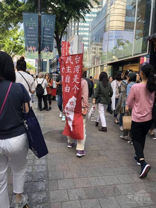 羅文凰隨韓國丈夫移居韓國30多年，仍相當關注台灣議題，曾為讓更多中國人關注台灣、香港議題，隻身背上布條在明洞觀光區進行「一人示威」。（羅文凰提供）