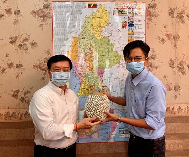 農友種苗股份有限公司總經理室助理陳學弘(右)致贈該公司新品種的巨型哈密瓜給駐緬甸代表處李朝成代表(左)
