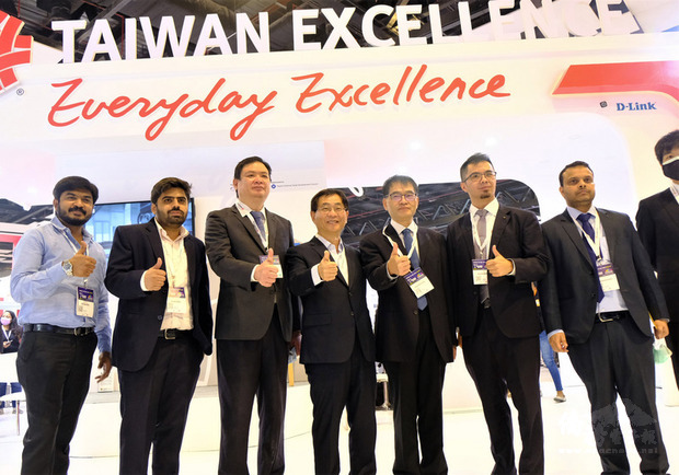 駐印度代表葛葆萱（左4）24日到2021年印度資通訊展台灣精品館參觀，並與經濟組官員、貿協人員及參展廠商一起合影，比讚為台灣精品宣傳。