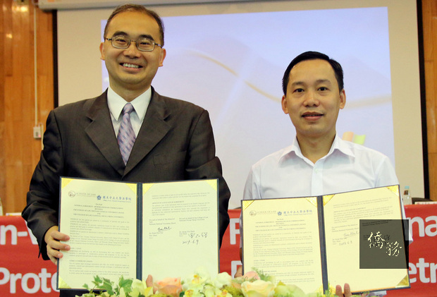 中正大學法學院副院長曾品傑（左）與越南國立大學河內代表簽署學術合作，建立台越兩國多元面向的合作與 發展。（圖／中正大學） 