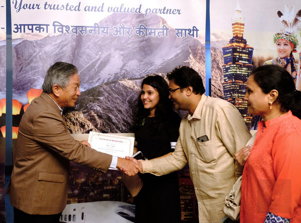 駐印度代表田中光（左）18日頒發台灣獎學金和教育部華語獎學金給79名印度學生，他在頒發獎學金時，親切與學生家長握手道賀。
