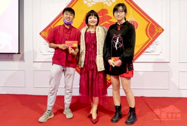 一身火紅的屏東科技大學副國際長簡赫琳(中)，頒獎給「紅色先生」得主余偉盛(左)與「紅色小姐」得主陳雪妮(右)。